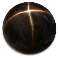 Star Diopside, Black Star of India . The 4-rayed star is caused by reflection of light at needle-shaped inclusions of magnetite.